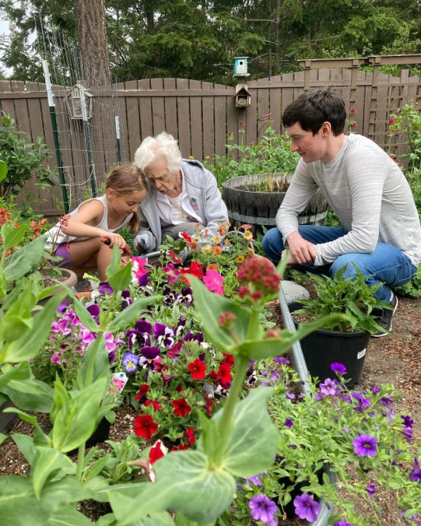 Grandma Sylvia teaching her great-grandchildren the art of gardening.